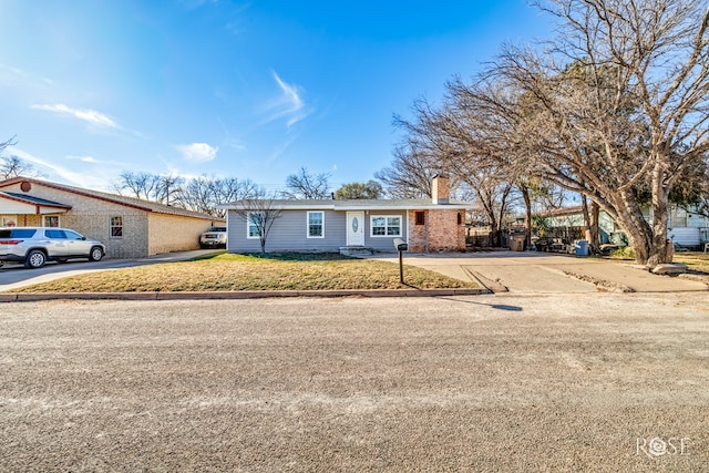 1611 Mission Ave, San Angelo, TX 76905 - ranch-style house with a chimney, driveway, a front lawn, and brick siding
