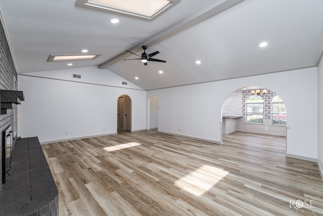 3853 Sandstone Rd, San Angelo, TX 76904 - unfurnished living room featuring arched walkways, a brick fireplace, ceiling fan, light wood-type flooring, and recessed lighting