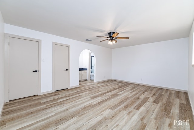 3853 Sandstone Rd, San Angelo, TX 76904 - unfurnished bedroom featuring arched walkways, light wood-type flooring, ensuite bath, and ceiling fan