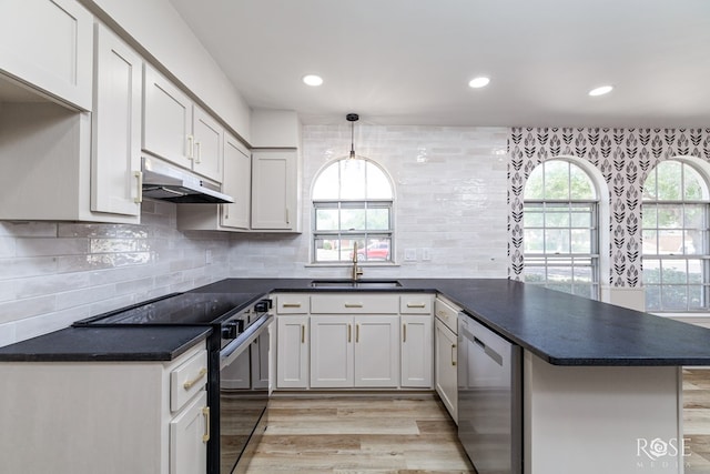 3853 Sandstone Rd, San Angelo, TX 76904 - kitchen featuring stainless steel dishwasher, black electric range oven, a peninsula, under cabinet range hood, and light wood-type flooring