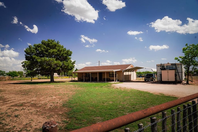 7229 Sun Ln, San Angelo, TX 76901 - back of property with a carport, driveway, an outbuilding, and a yard