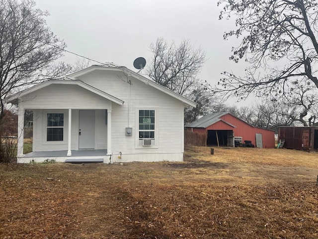 rear view of property featuring covered porch