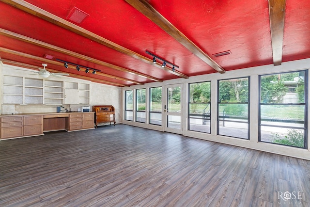 unfurnished sunroom with beam ceiling, built in desk, and track lighting