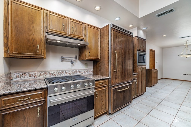 kitchen with stainless steel gas stove, light tile patterned floors, black microwave, and dark stone countertops