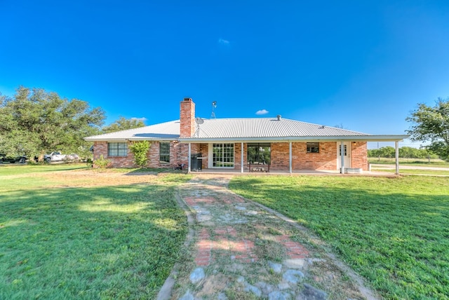 rear view of property with a lawn