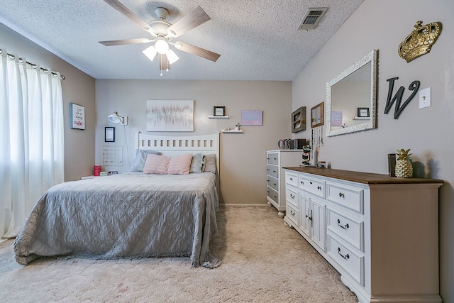 carpeted bedroom featuring a textured ceiling and ceiling fan