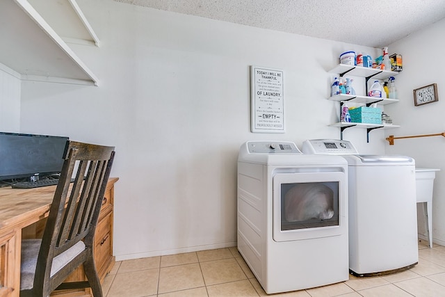 laundry room with light tile patterned floors, a textured ceiling, and washing machine and clothes dryer