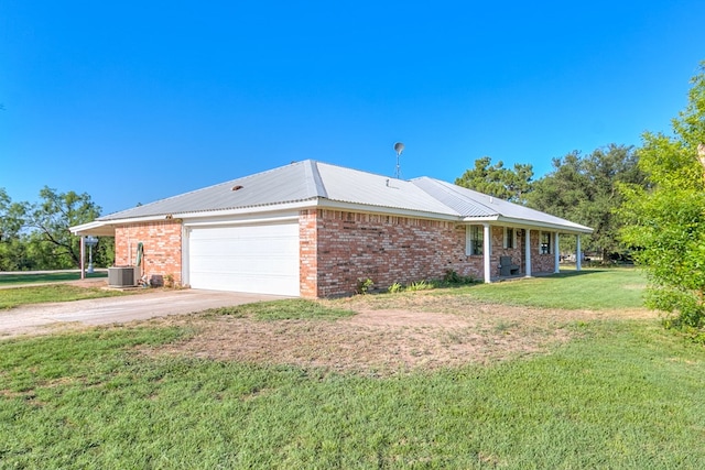 view of front facade featuring cooling unit, a garage, and a front lawn