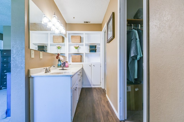 bathroom featuring vanity, wood-type flooring, and a textured ceiling