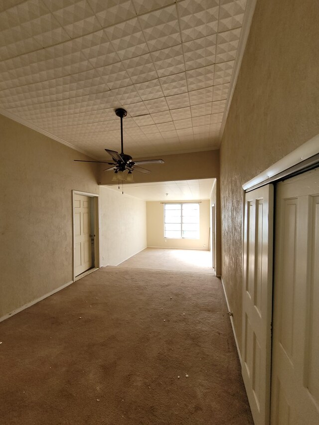 interior space featuring crown molding, carpet flooring, and ceiling fan