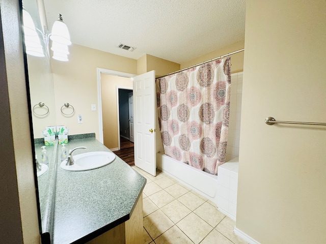 bathroom with vanity, tile patterned flooring, a textured ceiling, and shower / bath combo with shower curtain