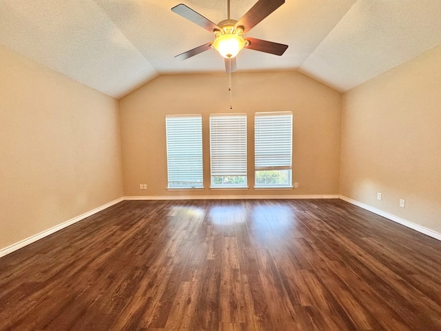 spare room featuring dark wood-type flooring, vaulted ceiling, a textured ceiling, and ceiling fan