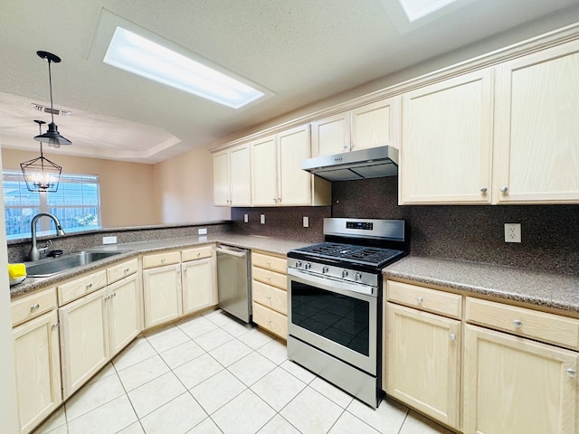 kitchen with light tile patterned flooring, appliances with stainless steel finishes, sink, and backsplash