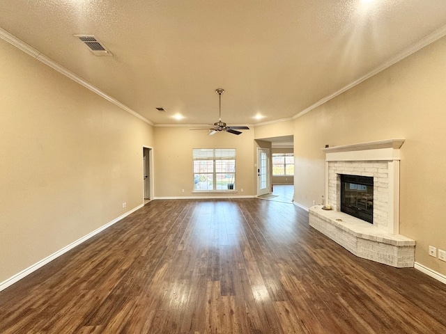 unfurnished living room with dark wood-type flooring, a textured ceiling, ornamental molding, ceiling fan, and a fireplace