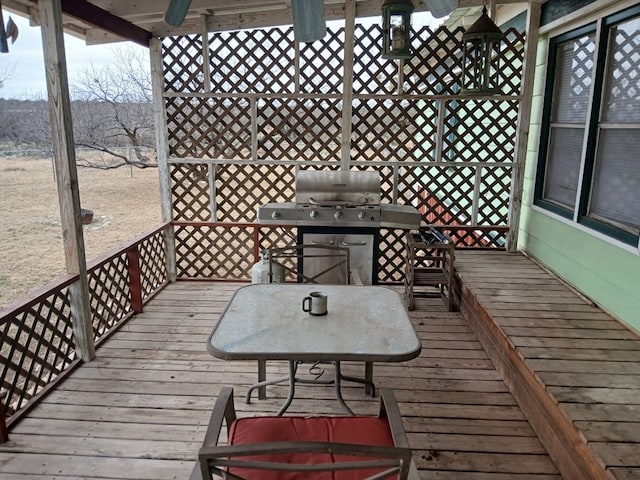 wooden terrace with outdoor dining area and grilling area