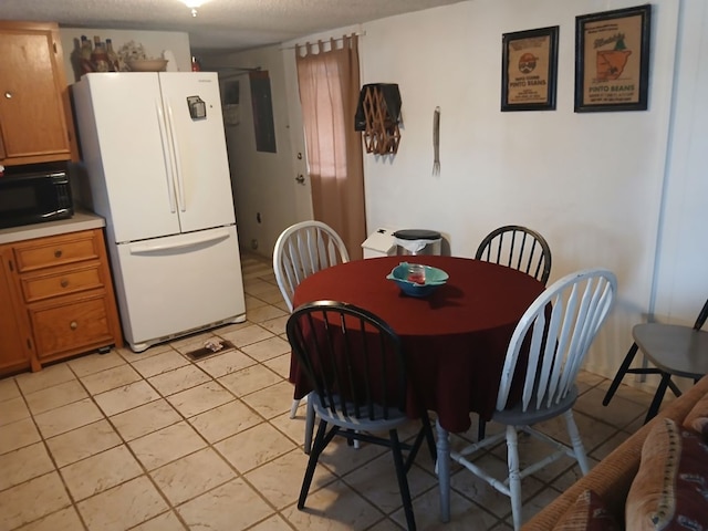 dining space with light tile patterned flooring and a textured ceiling