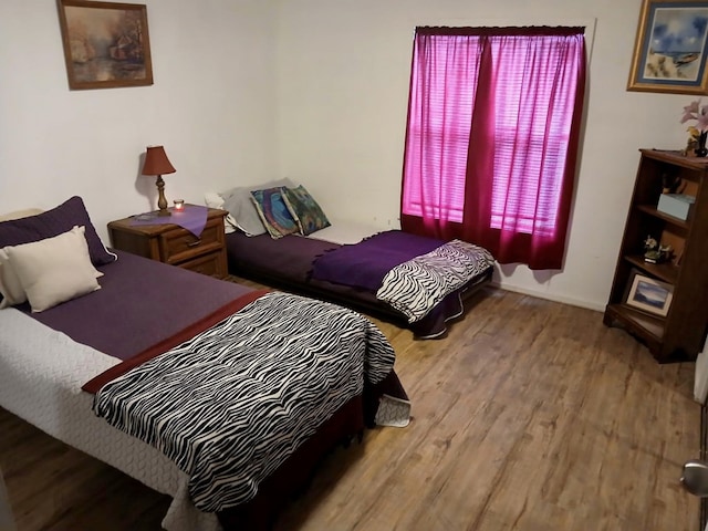 bedroom with baseboards and wood finished floors