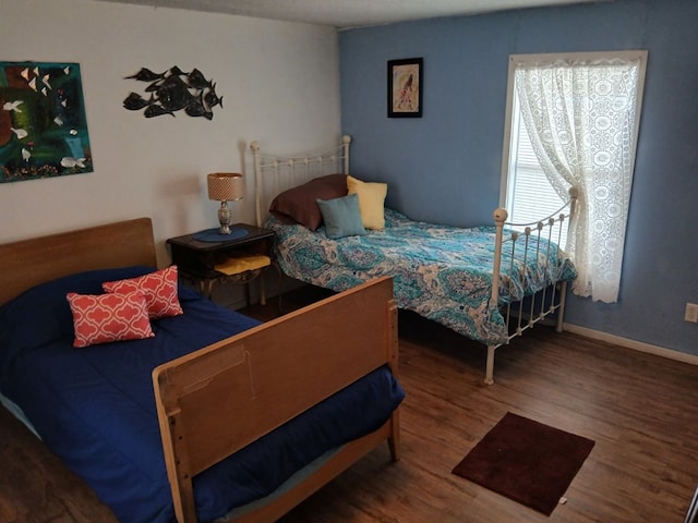 bedroom featuring wood finished floors and baseboards