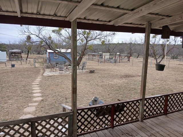 wooden deck featuring an outbuilding and fence