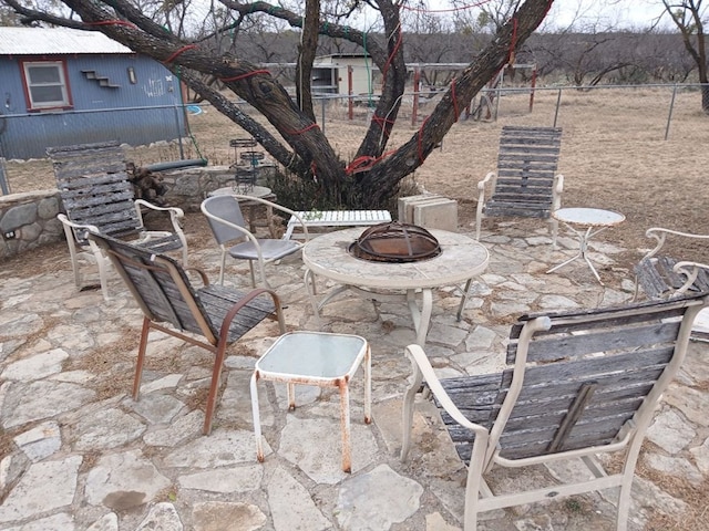 view of patio featuring a fire pit and fence