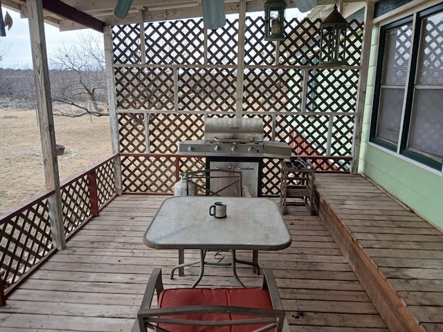 wooden terrace featuring outdoor dining area and a grill