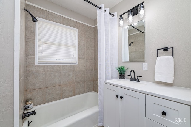 full bathroom featuring a textured wall, vanity, and shower / bath combination with curtain