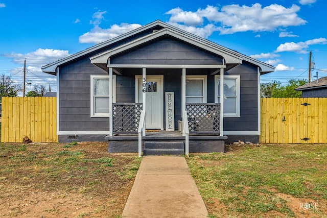 view of front of house featuring a porch, a front yard, and fence