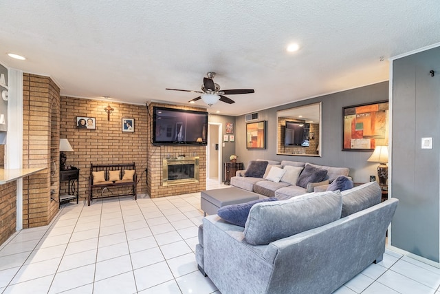 living room with a textured ceiling, ceiling fan, light tile patterned flooring, brick wall, and a brick fireplace