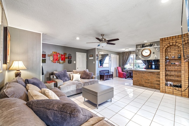 living room featuring light tile patterned floors, a textured ceiling, and a ceiling fan