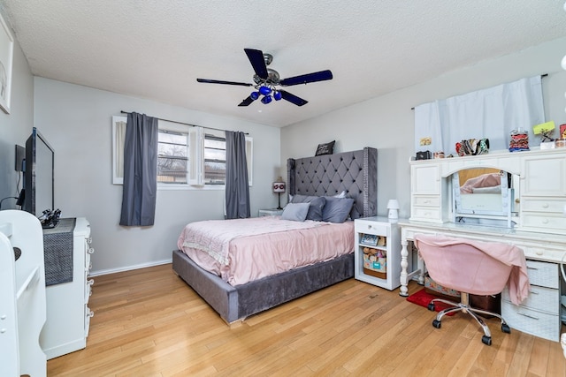 bedroom featuring light wood-type flooring, ceiling fan, a textured ceiling, and baseboards