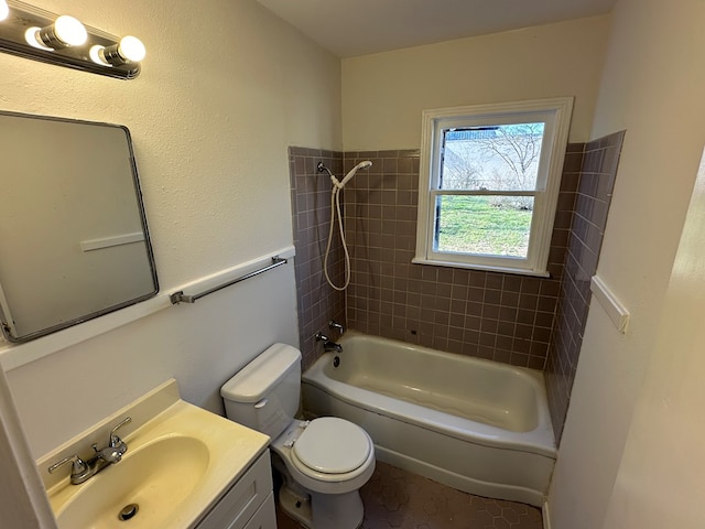 full bathroom with vanity, tiled shower / bath combo, tile patterned floors, and toilet