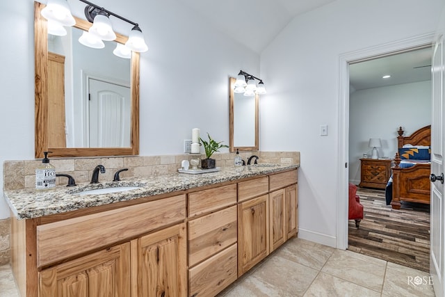 5292 Grey Wolf Ln, San Angelo, TX 76901 - ensuite bathroom featuring double vanity, vaulted ceiling, and tile patterned flooring