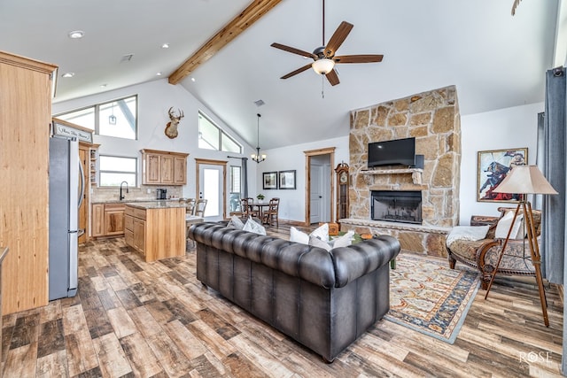 5292 Grey Wolf Ln, San Angelo, TX 76901 - living area featuring light wood finished floors, high vaulted ceiling, a ceiling fan, beamed ceiling, and a stone fireplace