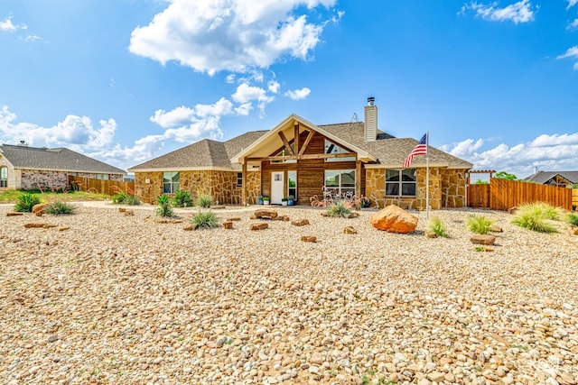 5292 Grey Wolf Ln, San Angelo, TX 76901 - back of house featuring stone siding, a chimney, a shingled roof, and a patio