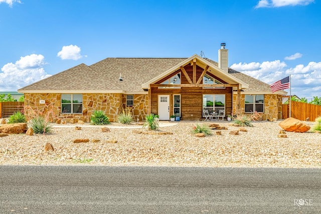 5292 Grey Wolf Ln, San Angelo, TX 76901 - view of front facade with stone siding, a shingled roof, and a chimney