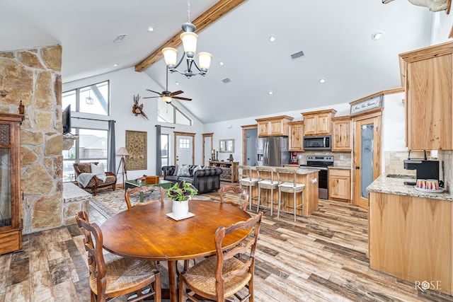 5292 Grey Wolf Ln, San Angelo, TX 76901 - dining area with high vaulted ceiling, a ceiling fan, beamed ceiling, light wood-style floors, and a chandelier