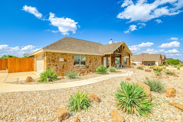 5292 Grey Wolf Ln, San Angelo, TX 76901 - view of front of property featuring stone siding, a chimney, a garage, a shingled roof, and driveway