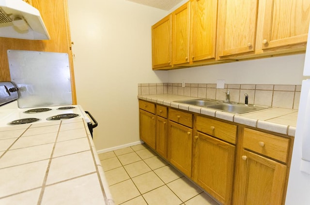 1901 Pulliam St, San Angelo, TX 76905 - kitchen featuring under cabinet range hood, a sink, white range with electric cooktop, tile counters, and light tile patterned floors