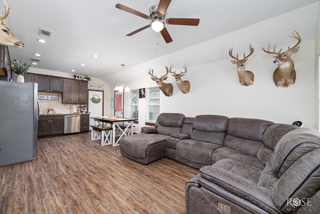 living room with visible vents, lofted ceiling, dark wood-style flooring, ceiling fan with notable chandelier, and recessed lighting