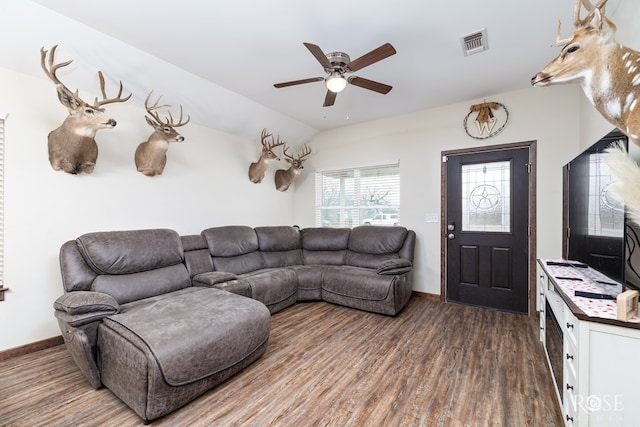 living room featuring dark wood-style floors, visible vents, a ceiling fan, vaulted ceiling, and baseboards