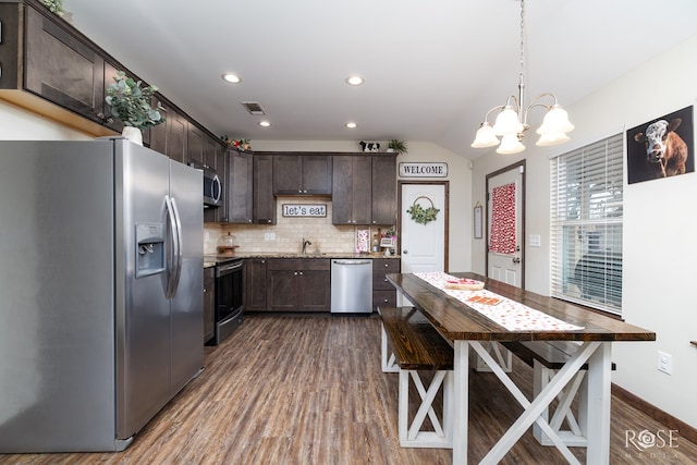 kitchen with visible vents, decorative backsplash, dark wood-style flooring, stainless steel appliances, and dark brown cabinets