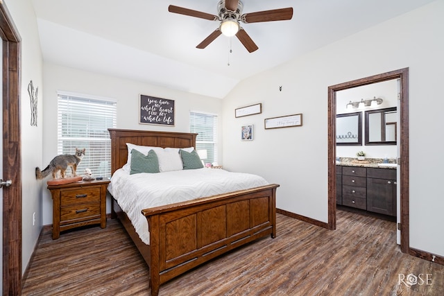 bedroom featuring dark wood finished floors, vaulted ceiling, baseboards, and ensuite bathroom