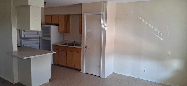 kitchen featuring sink, stainless steel fridge, and kitchen peninsula