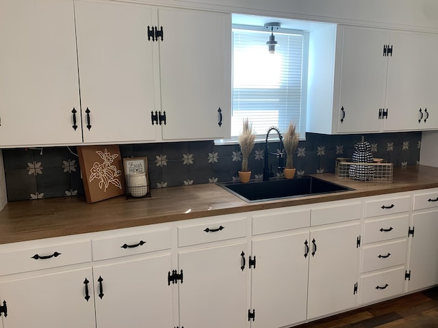 62 E 39th St, San Angelo, TX 76903 - kitchen featuring a sink, white cabinetry, tasteful backsplash, and dark wood-style flooring