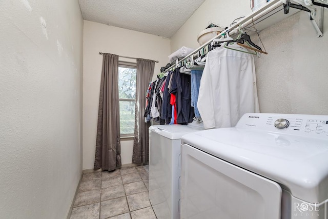 laundry area with separate washer and dryer and a textured ceiling