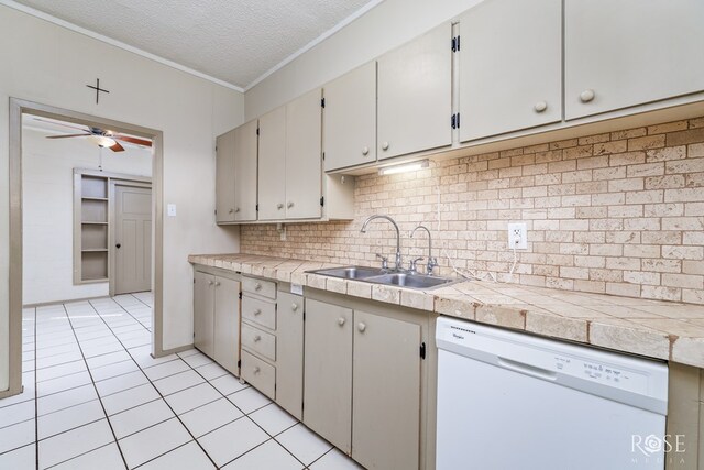 kitchen with sink, dishwasher, backsplash, a textured ceiling, and light tile patterned flooring