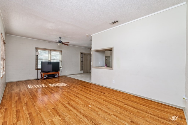 unfurnished living room featuring ceiling fan, light wood-type flooring, crown molding, and a textured ceiling