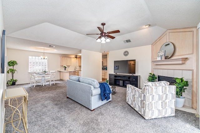 5221 Coral Way, San Angelo, TX 76904 - living room with carpet, ceiling fan, a chandelier, a tiled fireplace, and a textured ceiling