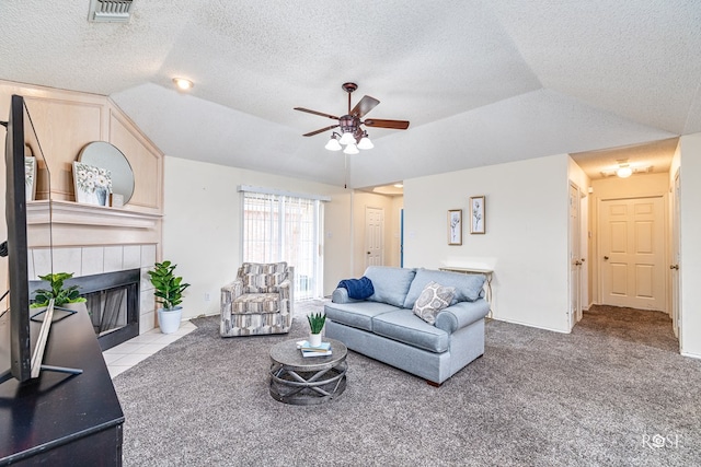5221 Coral Way, San Angelo, TX 76904 - living room featuring vaulted ceiling, ceiling fan, a textured ceiling, a fireplace, and carpet
