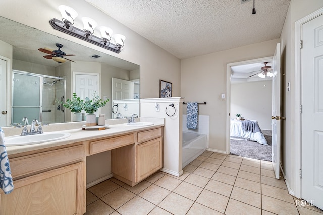 5221 Coral Way, San Angelo, TX 76904 - bathroom with a shower stall, ceiling fan, double vanity, tile patterned flooring, and a textured ceiling